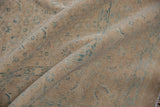 Folded vintage Birjand carpet pile, showing soft distressed texture in sand beige with blue Herati motifs.