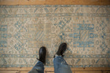 Visible wear and geometric pattern on distressed vintage Karaja runner in ivory and blue.