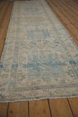 Distressed vintage Karaja runner pile with geometric blue motifs, faint foundation.