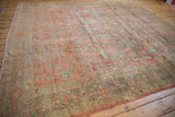 Corner of distressed vintage Lilihan carpet, featuring muted floral borders and secured fringe.