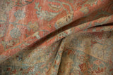 Distressed texture of vintage Lilihan carpet showing faded reds, ocean blue, and golden brown.