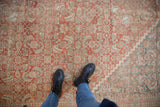 Distressed Mahal carpet section with dusty red Herati pattern, stepped corner, and worn texture.