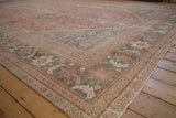 Distressed vintage Mahal carpet corner with palmette and pawn borders, time-softened hues.