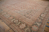 Corner of distressed Mahal carpet, featuring faded brick red, slate, and sand palmette and pawn borders.
