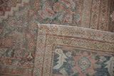 Folded corner of a vintage distressed Mahal carpet, revealing muted Herati pattern, pile wear, and intact selvage.