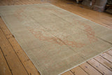 Low-angle view of the vintage Kayseri carpet, showing its faded terracotta and beige floral design.