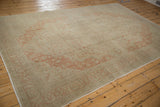 Angled view of a distressed Kayseri carpet with a faded terracotta medallion on a dusty beige field.