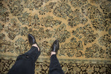 Distressed low-pile texture showing knot heads on the floral pattern of a vintage Arak carpet.