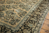 Corner view of a vintage Arak carpet's distressed pile, contrasting the ivory floral field with the dark brown border.