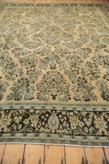 Low-angle view of a vintage Arak rug's distressed texture and floral pattern.