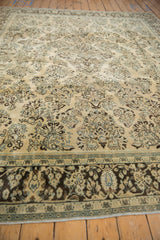 Dark brown floral border framing the distressed ivory field of a vintage Persian Arak carpet.