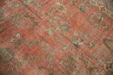 Distressed Mahal carpet close-up: dusty raspberry field, faded floral pattern, visible foundation.