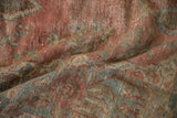 Distressed vintage Mahal carpet showing textured wear to foundation, dusty red and blue floral pattern.