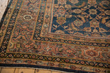 Intricate terracotta, blue, ivory border patterns on a vintage Mahal carpet, with mostly even wear.