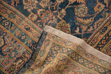 Vintage Mahal carpet folded, showing dark denim, terracotta Herati pattern and woven reverse.