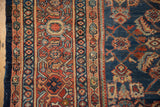 Mahal carpet border detail with intricate terracotta and sky blue patterns adjacent to the dark denim blue field.