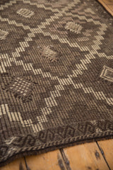 The distinct reciprocating wave and serpent motif in the distressed Jijim carpet border.