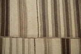 Close-up of vintage Turkish Kilim patchwork with brown and greige vertical stripes and horizontal seam.