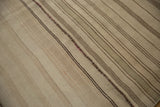 Patchwork seam detail on the hand-woven Turkish Kilim with greige and brown stripes.