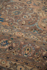 Distressed Kashan carpet texture, faded dusty mauve, peach, and sky blue floral patterns.
