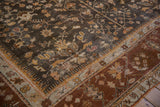 Vintage Oushak carpet's charcoal field with vinery meets its wide banded chestnut border.