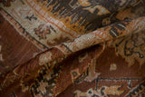 Oushak rug fold detail showing chestnut, saffron, and ivory botanical patterns.