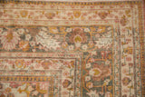 Distressed Doroksh carpet corner, showing floral vinery, raspberry, saffron, and worn foundation.