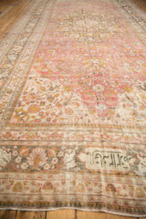 Distressed Doroksh carpet's weaver inscription cartouche, faded floral vinery, and visible foundation.