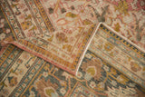 Distressed Doroksh carpet folded, revealing worn pile, exposed foundation, and muted raspberry, saffron.
