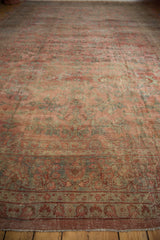 Distressed vintage Mahal carpet close-up with low pile floral pattern, border, and frayed fringe.