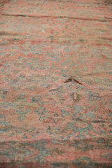 Distressed Mahal carpet detail: worn pile, faded floral pattern in dusty blush and teal.