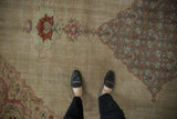 Worn, low pile texture on a distressed Tabriz carpet showing the beige field and dusty blue Herati corner design.
