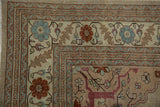 Evenly worn corner of a vintage Tabriz rug with detailed floral borders in blue and rust.