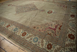 Corner spandrel of a distressed Tabriz rug featuring a raspberry red animal and floral motifs.