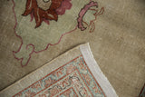 A distressed Tabriz carpet corner folded to show the hand-knotted back and restored selvage.