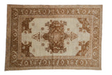 Vintage distressed Oushak rug with a coffee brown medallion and floral border on a neutral ivory field.