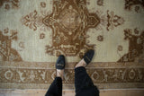 An overhead view showing the scale and time-softened texture of a vintage distressed Oushak rug.