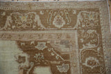 Close-up of the corner showing the Oushak rug's worn pile and floral arabesque main border.