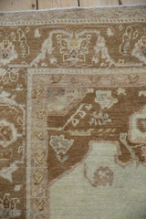 Worn pile on the corner spandrel and floral arabesque border of a vintage Oushak rug.