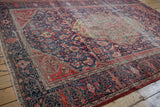 Worn intricate red and navy floral vinery on an antique Persian Farahan Sarouk corner.