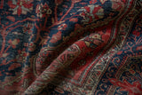Intricate red and navy vinery with decorative border on antique Farahan Sarouk.