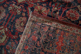Folded antique Farahan Sarouk carpet revealing intricate navy, red floral pattern and reverse weave.