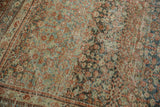 Distressed vintage Mahal carpet corner with dusty teal, red henna plant motifs, and samovar border.