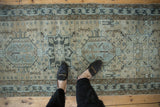 Distressed vintage Karaja runner detail: hexagonal medallion, human effigies, greige and slate blue.