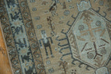 Distressed Karaja rug's hexagonal medallion, human effigies, and worn knot heads on a greige field.