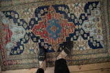 Vintage Northwest Persian rug with shield medallion, starbursts, navy, cherry red, sky blue, uniform wear.