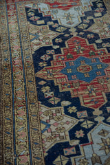 Vintage Northwest Persian rug: geometric border, navy field with starburst and halved medallion.