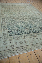 Angled view down the distressed vintage Hamadan carpet, showing the low-pile texture and allover Herati motif.