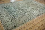 Angled perspective of a vintage Hamadan carpet showing its distressed allover pattern and muted color palette.