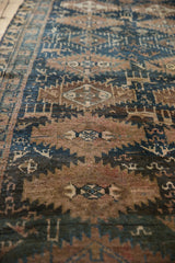 Vintage distressed Kurd runner pile, highlighting geometric patterns in blue and coppery brown.